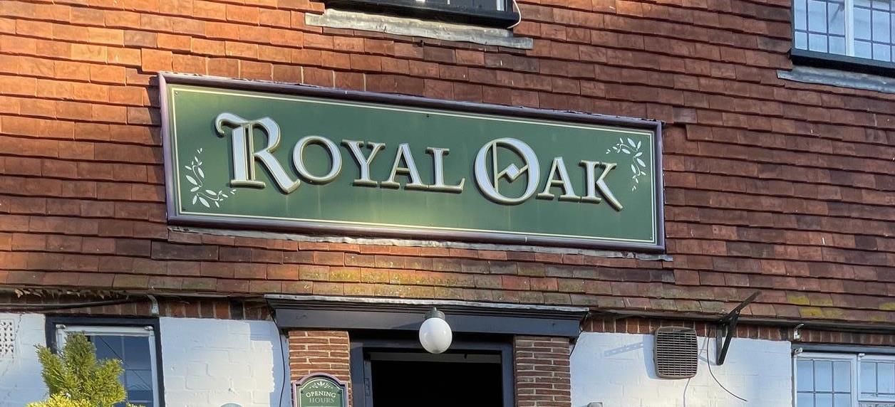 Image of a pub sign on a red tiled background