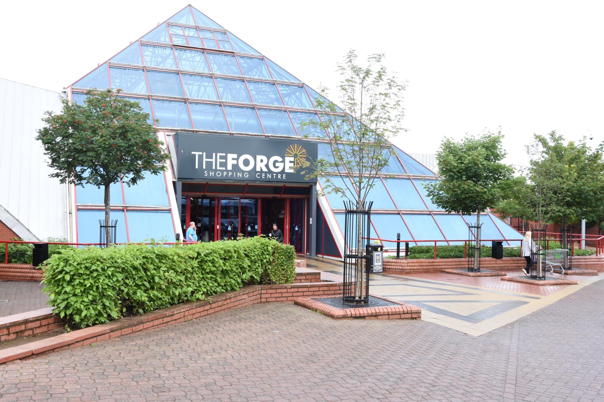 Exterior of The Forge Shopping Centre with a pyramid shaped glass front.