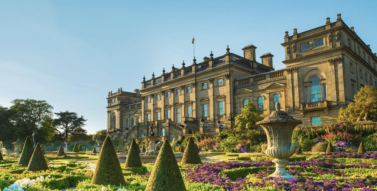 A view of the South Front of the 18th Century House from the Terrace Garden, on a clear day with blue sky and sunshine.