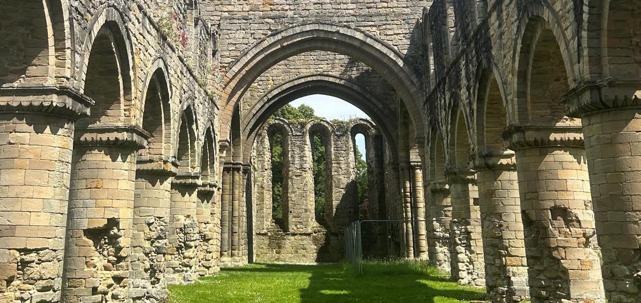 Image of a stone archway with arches and arches in a grassy area